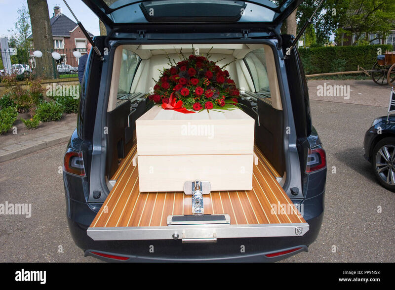a-coffin-with-a-flower-arrangement-in-a-funeral-car-PP9N58.jpg